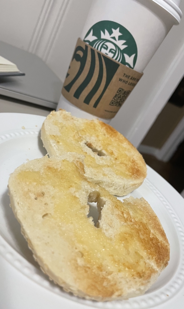 Image shows a toasted bagel with butter and a Starbucks coffee drink enclosing a pumpkin spiced latte.